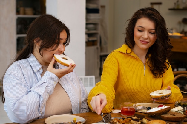 Mulheres de tiro médio com comida deliciosa