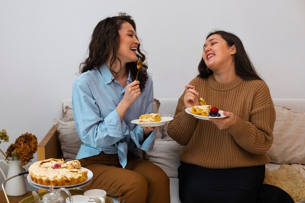 Mulheres de tiro médio com comida deliciosa