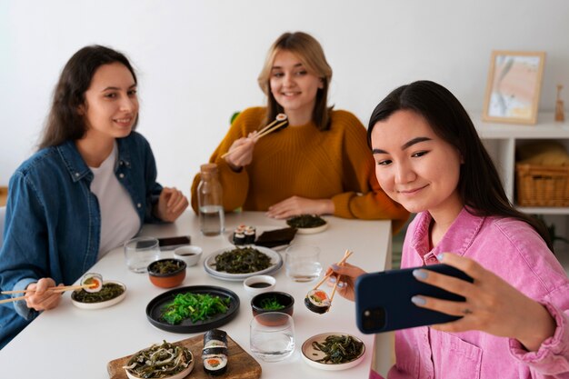 Mulheres de tiro médio comendo juntas