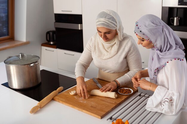 Mulheres de tiro médio cozinhando para o ramadã