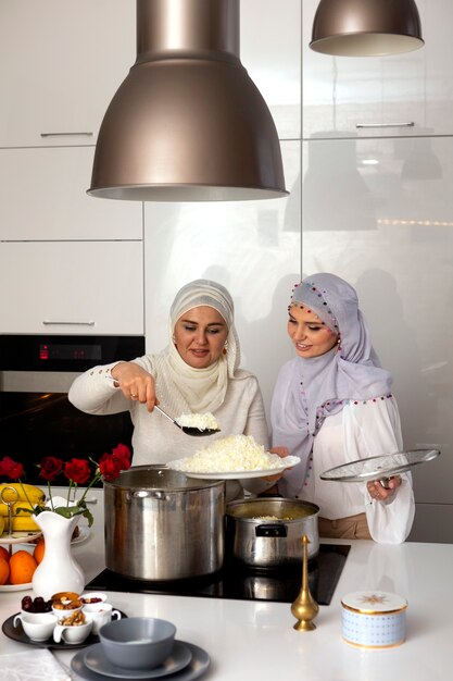 Mulheres de tiro médio cozinhando para o ramadã