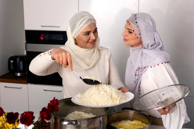 Mulheres de tiro médio cozinhando para o ramadã