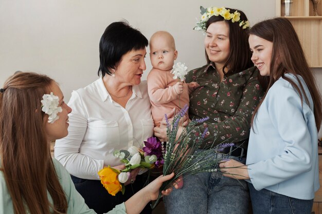 Mulheres de vista frontal com criança e flores