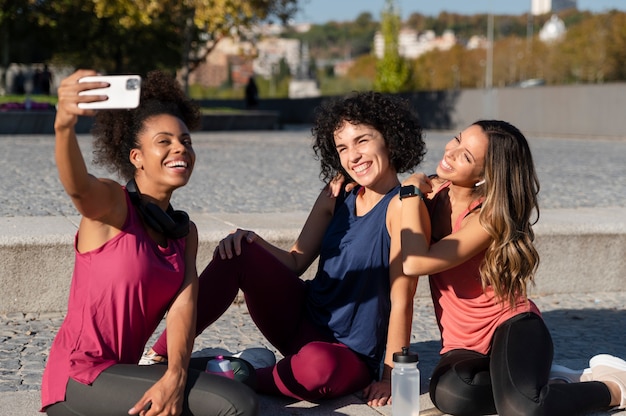 Foto grátis mulheres desportivas com tiro médio tirando selfie