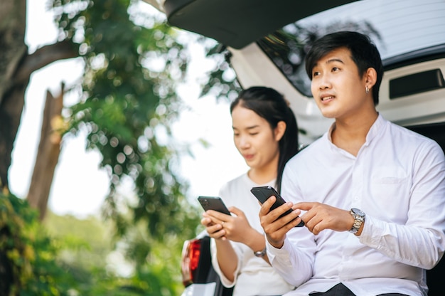 Mulheres e homens sentados em telefones celulares na parte de trás do carro