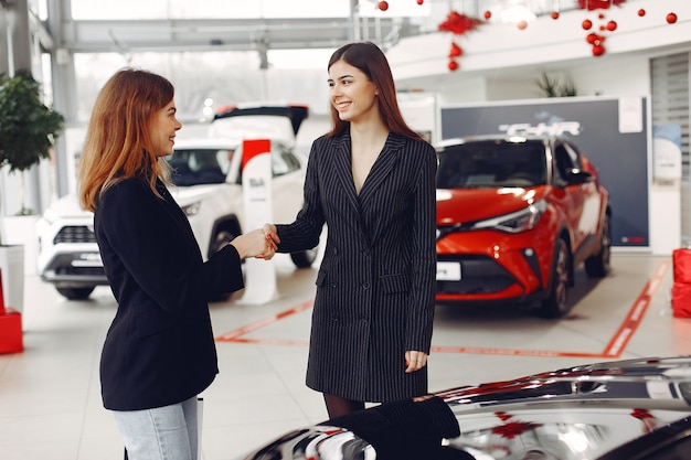 Mulheres elegantes e elegantes em um salão de automóvel