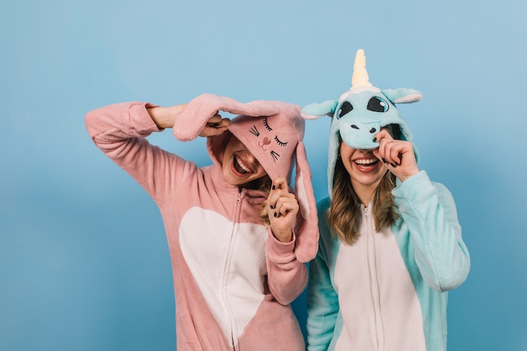 Foto grátis mulheres elegantes em kigurumi juntas na parede azul
