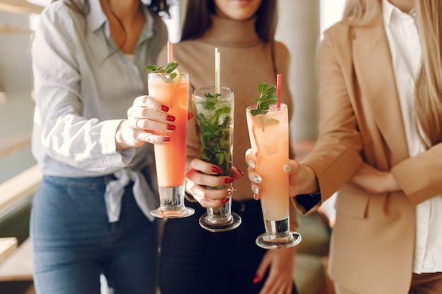 Mulheres elegantes em pé em um café e beber um cocktail