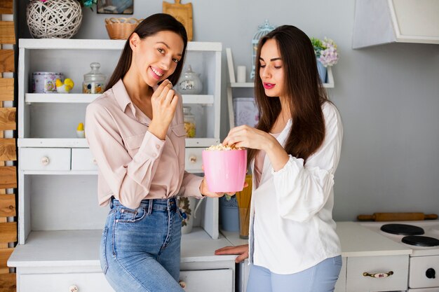 Mulheres em casa comendo pipoca