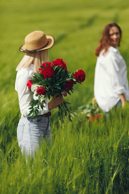 Mulheres em roupas elegantes, de pé em um campo de verão