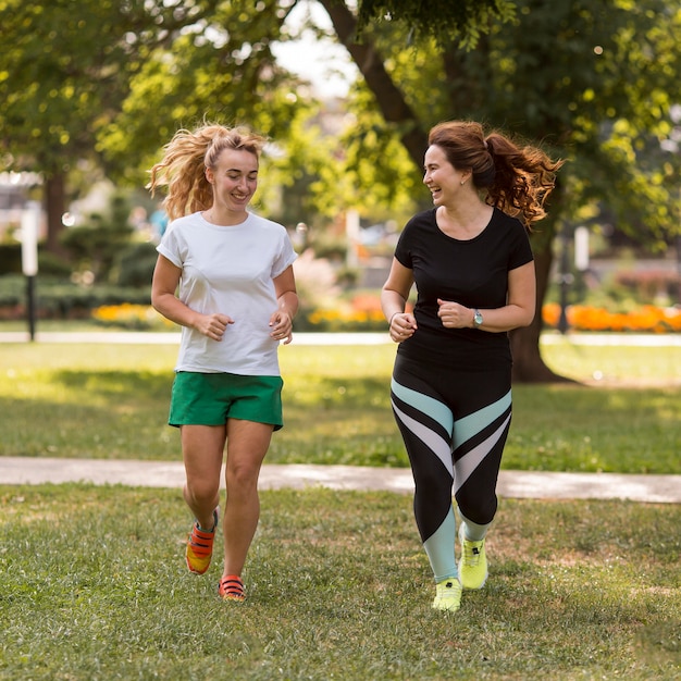Mulheres em roupas esportivas correndo juntas fora