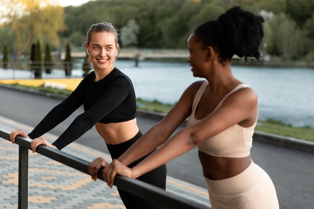 Mulheres em roupas esportivas malhando ao ar livre