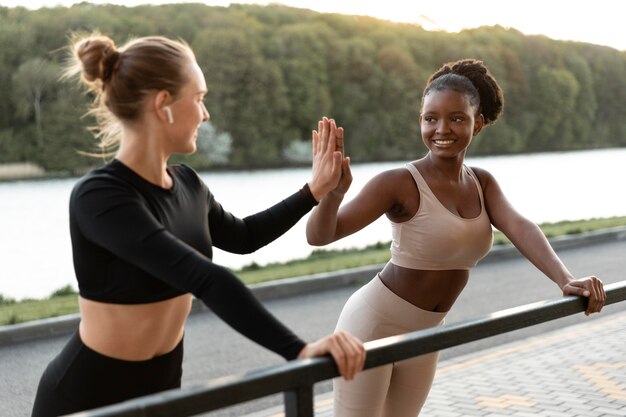 Mulheres em roupas esportivas malhando ao ar livre