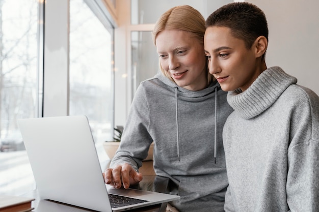 Mulheres em tiro médio com laptop