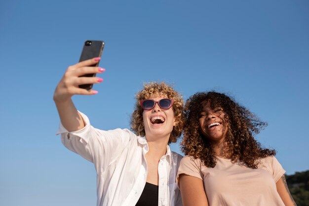 Mulheres em tiro médio tirando selfie