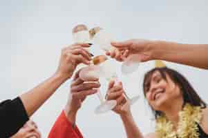 Foto grátis mulheres felizes animando taças de champanhe na festa no terraço