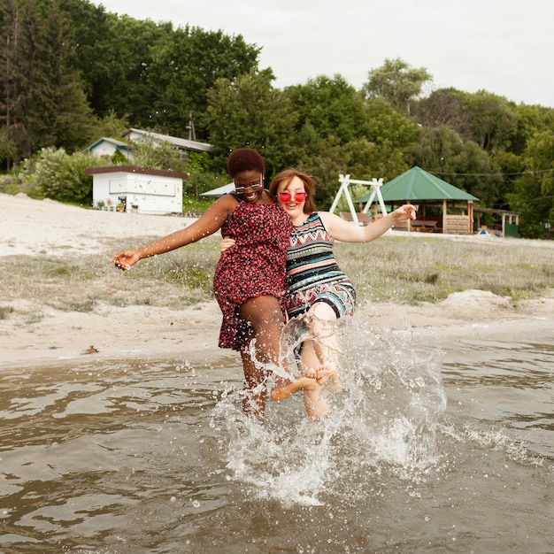 Mulheres felizes brincando com água na praia