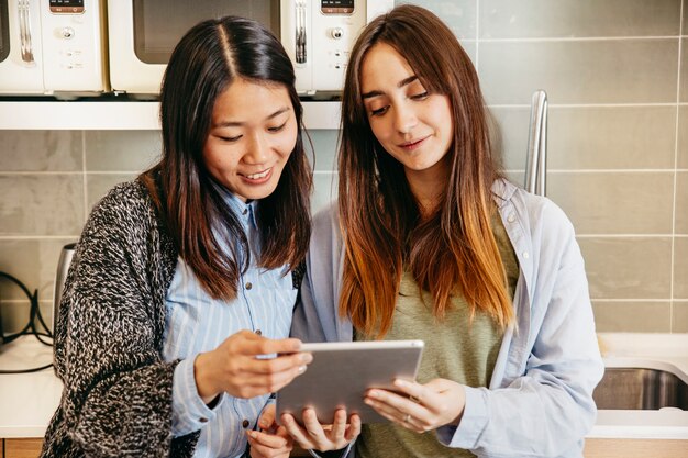 Foto grátis mulheres felizes com tablet na cozinha