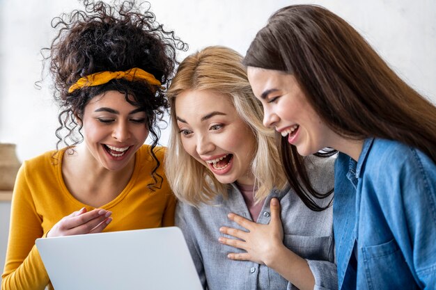 Mulheres felizes e rindo usando laptop