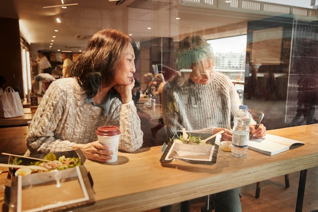 Mulheres idosas com tiro médio comendo alimentos saudáveis