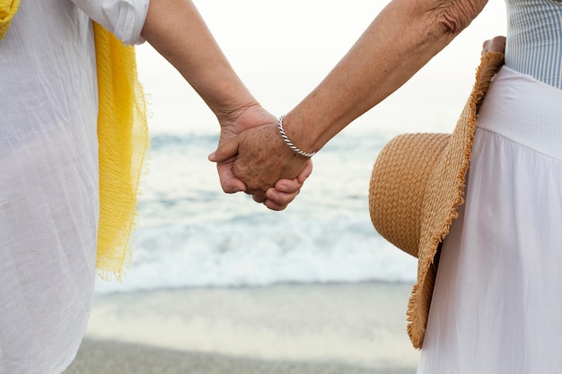 Mulheres idosas de mãos dadas na praia