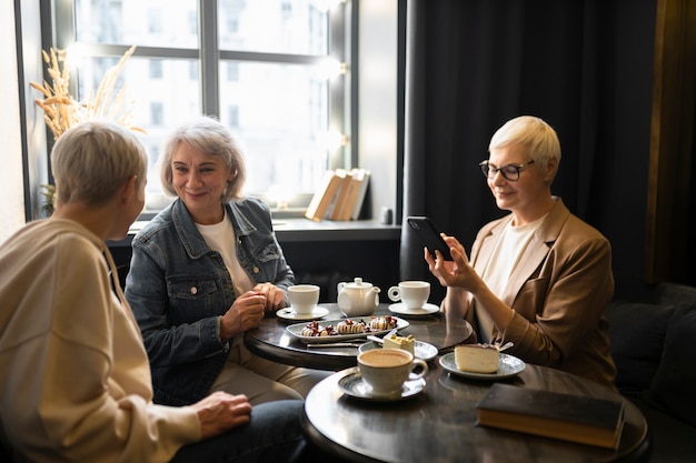 Mulheres idosas tomando café e conversando durante uma reunião