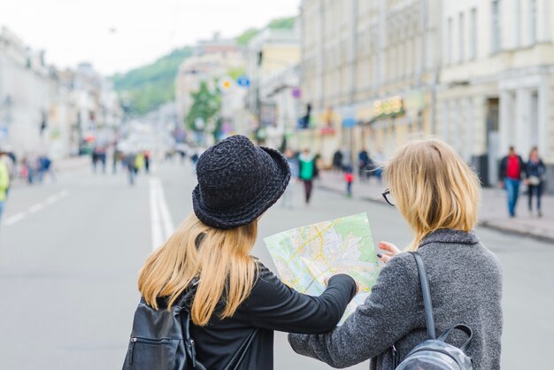 Mulheres irreconhecíveis navegando com o mapa