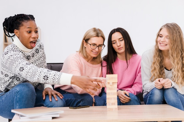 Mulheres jogando juntos um jogo da torre de madeira