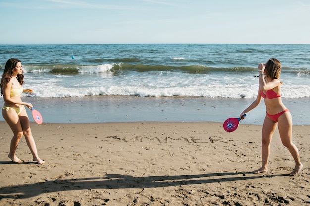 Mulheres jogando pingue-pongue na praia