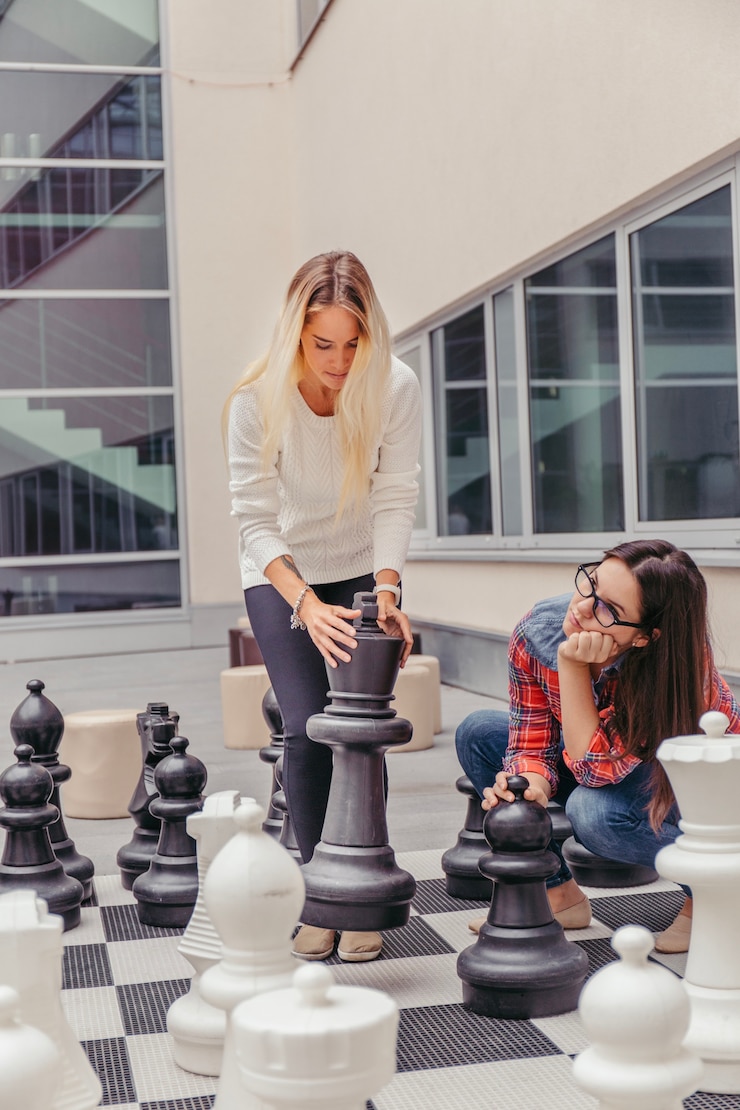 Foto grátis mulheres jogando xadrez gigante