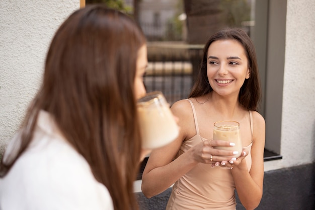Foto grátis mulheres jovens bebendo café gelado