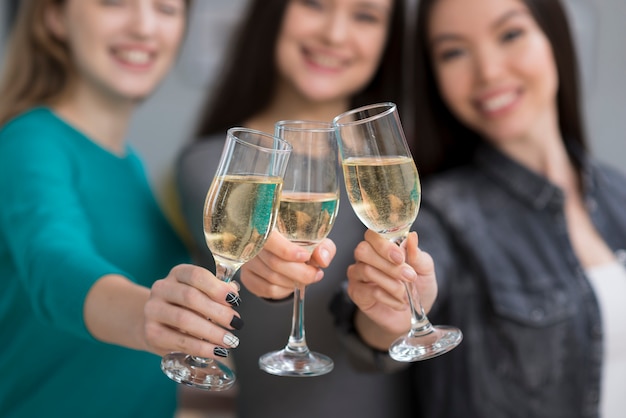 Mulheres jovens bonitos de close-up tomando champanhe juntos