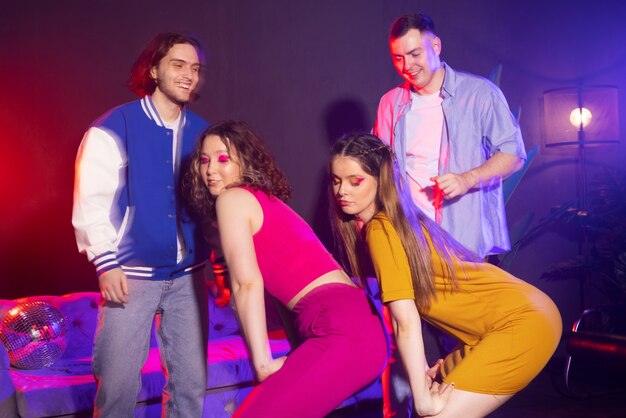 Mulheres jovens de tiro médio rebolando na festa