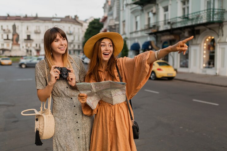Foto grátis mulheres jovens elegantes viajando juntas pela europa usando vestidos e acessórios da moda para a primavera