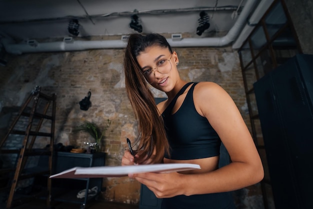 Mulheres jovens em pé escrevendo algo no caderno