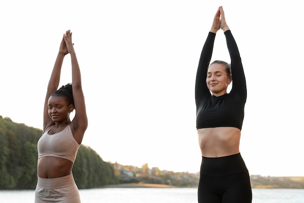 Mulheres jovens em roupas esportivas malhando ao ar livre