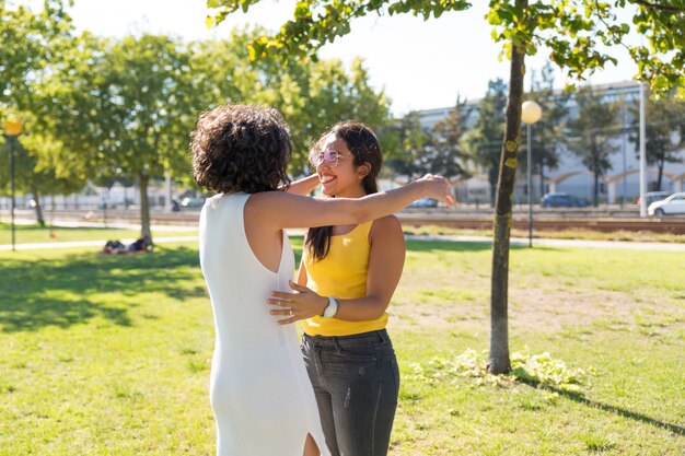 Mulheres jovens felizes abraçando no parque