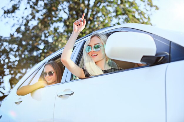 Mulheres jovens no carro sorrindo