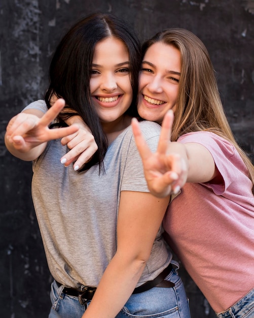 Mulheres jovens posando com o símbolo da paz