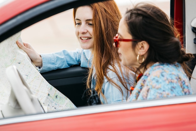 Mulheres jovens, sentar carro, e, olhar, mapa