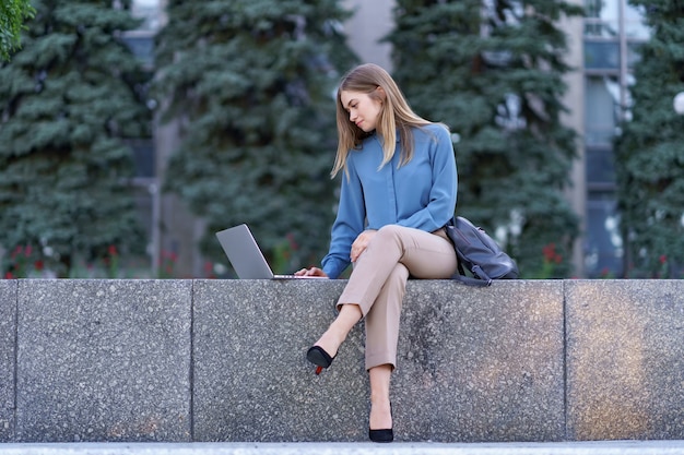 Mulheres jovens trabalhando em um laptop na praça da cidade