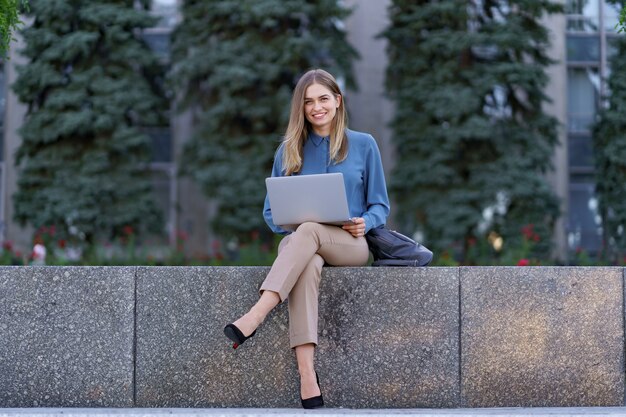 Mulheres jovens trabalhando em um laptop na praça da cidade