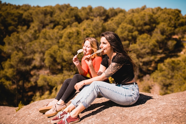 Mulheres lambendo pirulitos no penhasco