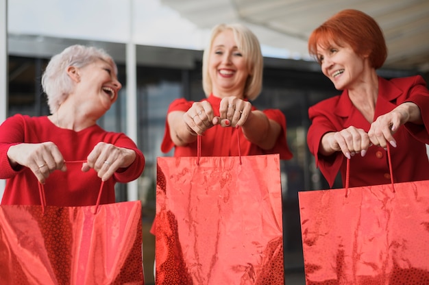 Mulheres maduras com sacos sorrindo