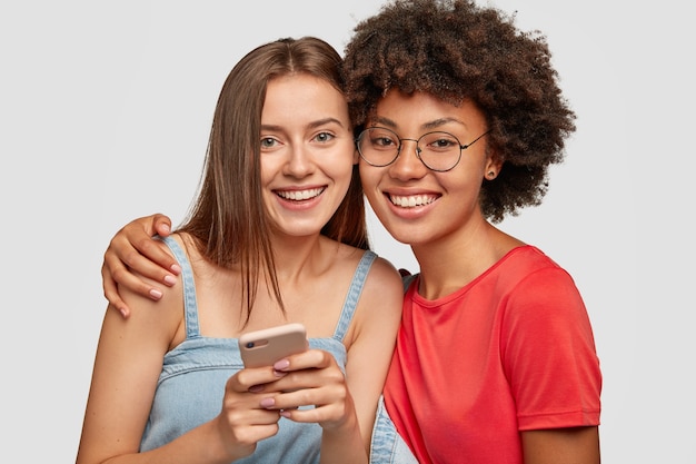 Foto grátis mulheres mestiças amigáveis se abraçam e sorriem juntas