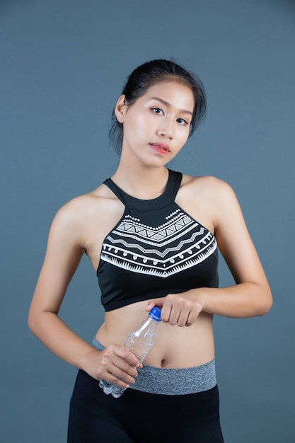 Mulheres no sportswear segurar uma garrafa de água potável