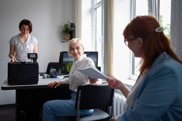Mulheres no trabalho no escritório usando impressora