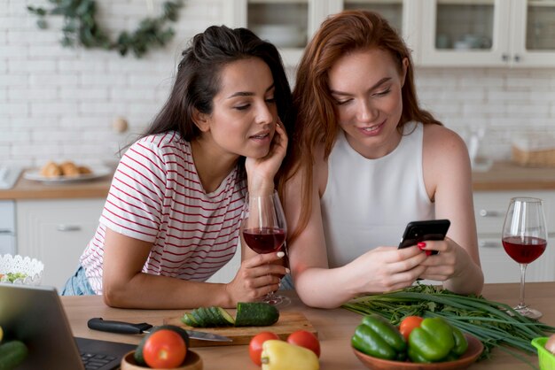 Mulheres olhando para o telefone na cozinha