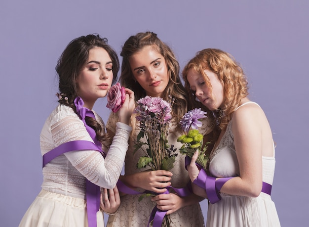 Mulheres posando com buquês de flores