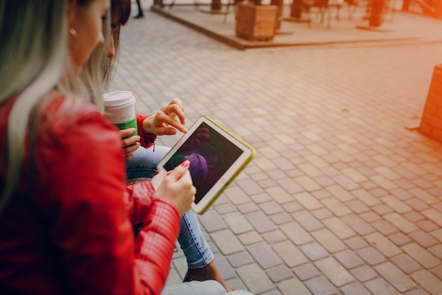 Mulheres que tocam em um tablet